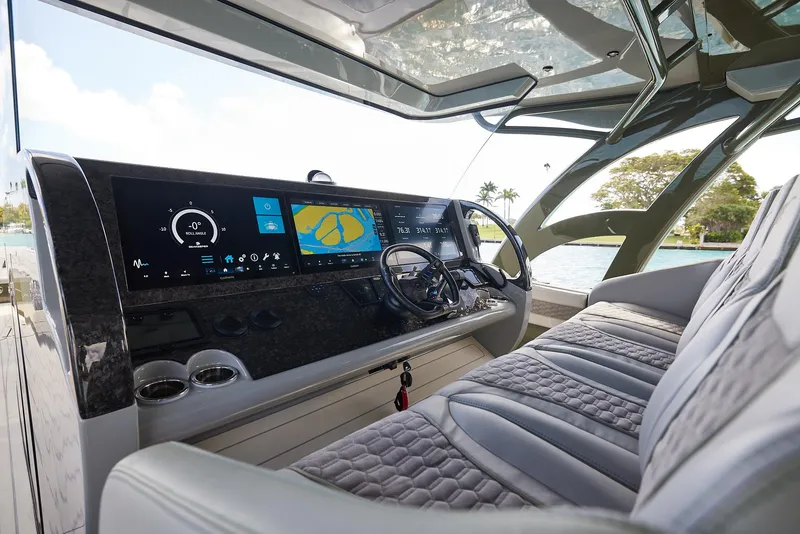 Slide: The Image of 2025 Midnight Express 52' Vitesse yacht cockpit with advanced navigation displays and luxurious seating. - 11