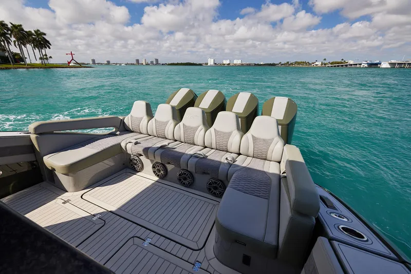 Slide: The Image of 2025 Midnight Express 52' Vitesse luxury boat interior with seating, cruising on turquoise waters. - 19