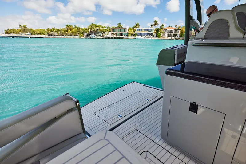 Slide: The Image of 2025 Midnight Express 52' Vitesse yacht on turquoise water near luxury waterfront homes. - 22