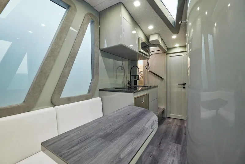 Slide: The Image of Interior of 2025 Midnight Express 52' Vitesse yacht, featuring modern kitchen and seating area. - 25