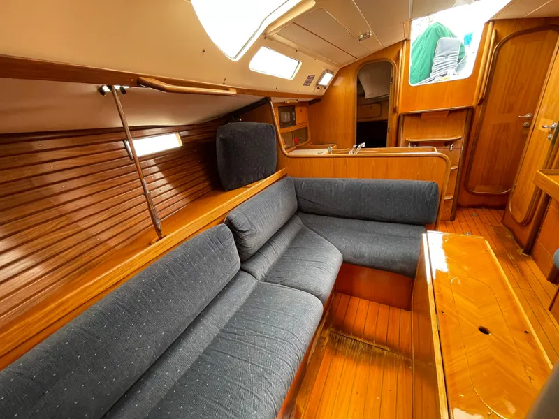 Slide: The Image of Interior of 1991 Beneteau Oceanis 390 sailboat with wooden finish and blue seating. - 10
