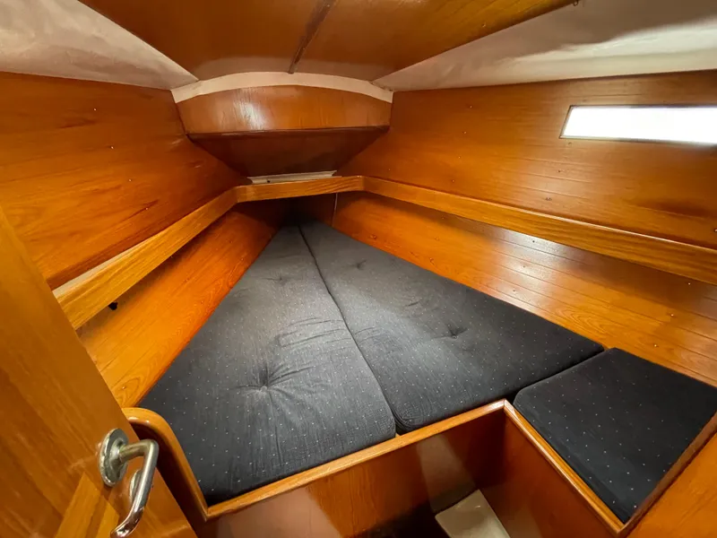 Slide: The Image of Cozy cabin interior of 1991 Beneteau Oceanis 390 sailboat with wooden finish and cushioned bed. - 11