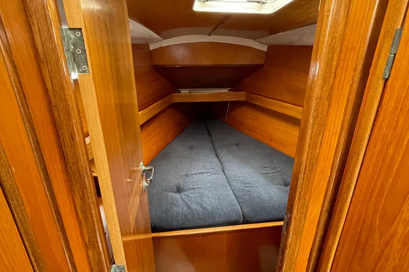 Slide: The Image of Cozy cabin interior of 1991 Beneteau Oceanis 390 sailboat with wooden finish and cushioned bed. - 13