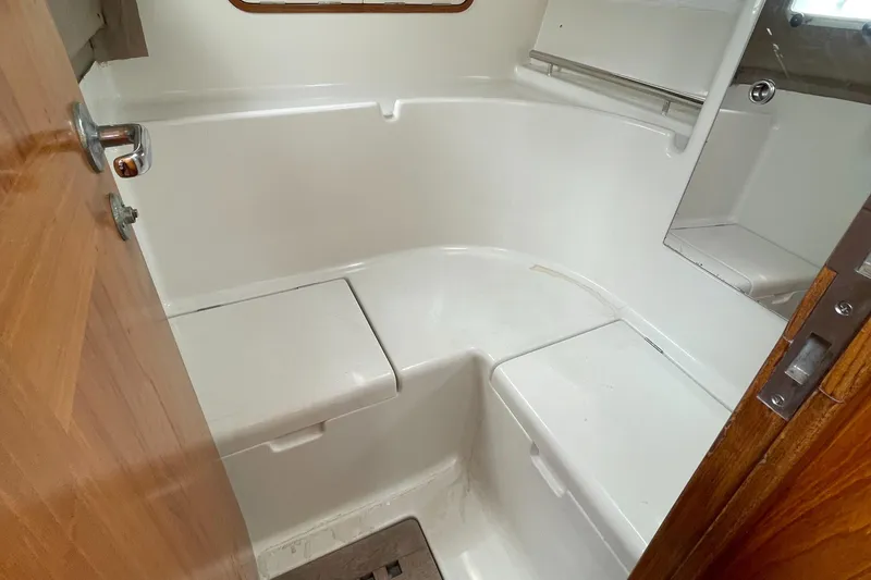 Slide: The Image of Bathroom interior of 1991 Beneteau Oceanis 390 yacht, featuring white fixtures and wooden accents. - 14