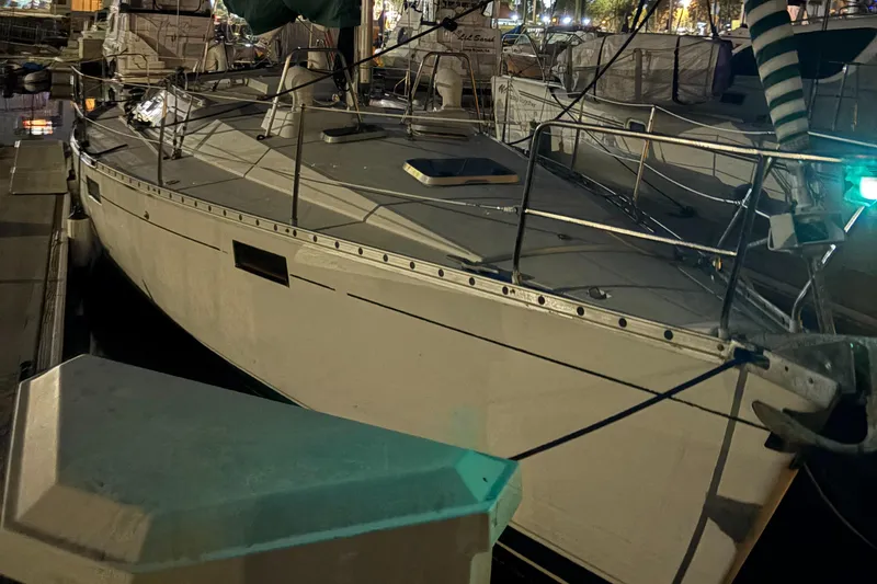 Slide: The Image of 1991 Beneteau Oceanis 390 sailboat docked at night, illuminated by marina lights. - 17