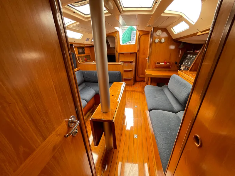 Slide: The Image of Interior of 1991 Beneteau Oceanis 390 sailboat with wooden finish and blue seating. - 18