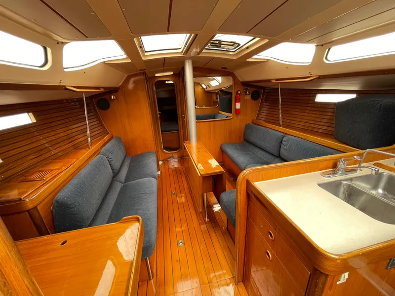 Slide: The Image of Interior of 1991 Beneteau Oceanis 390 sailboat with wooden finish and blue seating. - 3