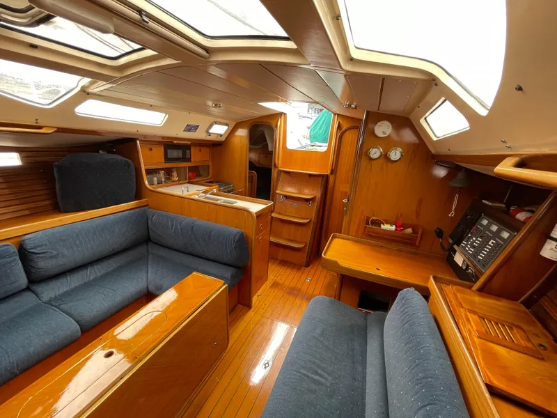 Slide: The Image of Interior of 1991 Beneteau Oceanis 390 sailboat with wood finish and blue seating. - 5
