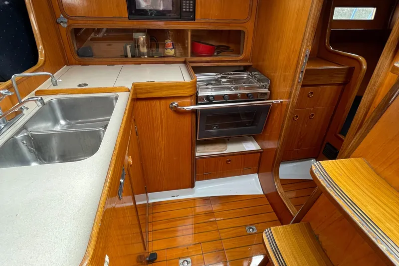 Slide: The Image of Interior of 1991 Beneteau Oceanis 390 yacht kitchen with wood finish and stainless steel sink. - 6