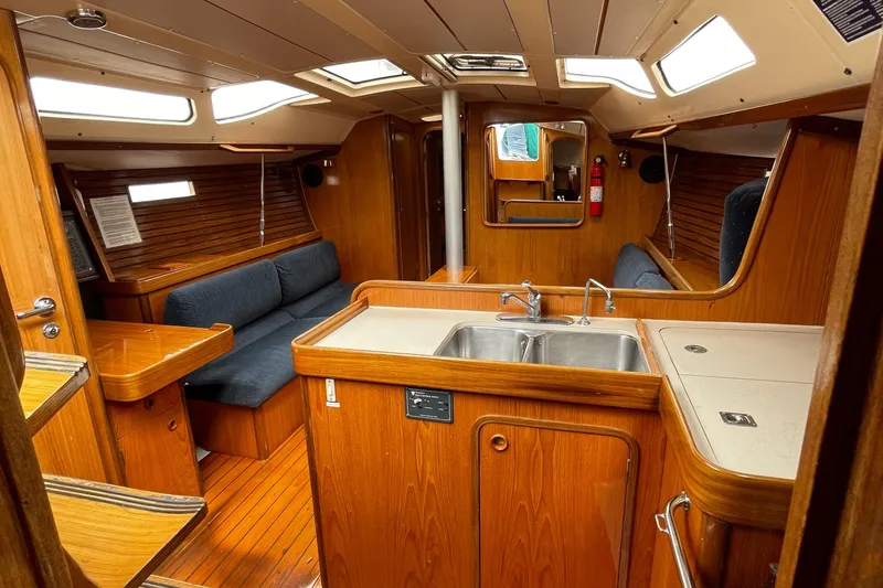 Slide: The Image of Interior of 1991 Beneteau Oceanis 390 sailboat with wood finish and seating area. - 9