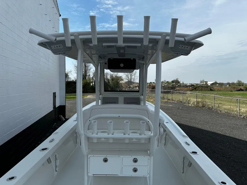 Slide: The Image of 2025 Pair Customs 27 boat with T-top and rod holders, docked outdoors. - 10