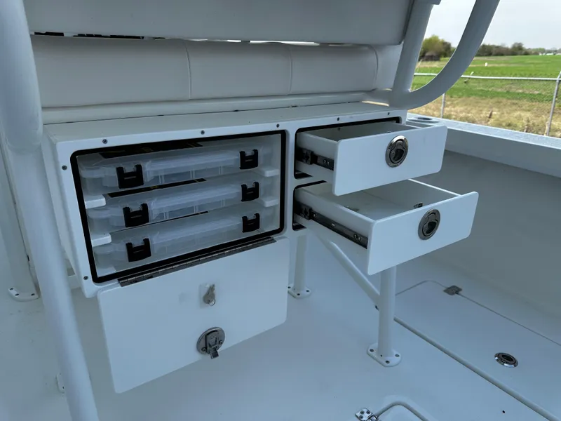 Slide: The Image of Storage compartments and drawers on a 2025 Pair Customs 27 boat, featuring organized tackle boxes. - 12