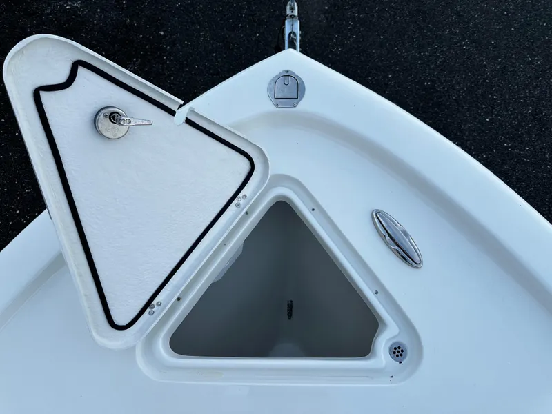 Slide: The Image of Open storage compartment on 2025 Pair Customs 27 boat, featuring a triangular hatch. - 16