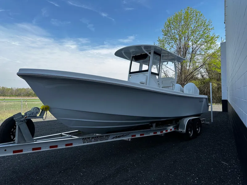 Slide: The Image of 2025 Pair Customs 27 boat on trailer, parked outdoors near a building. - 4