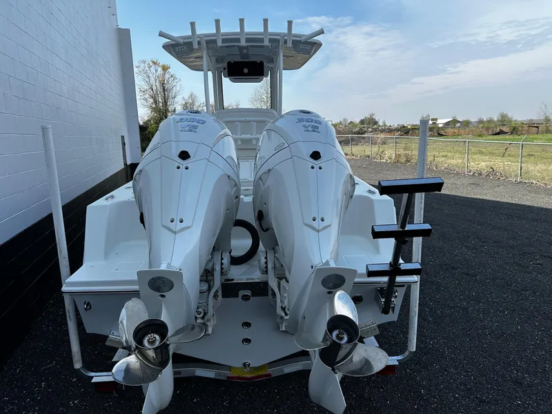 Slide: The Image of 2025 Pair Customs 27 boat with dual outboard motors, docked outdoors. - 6