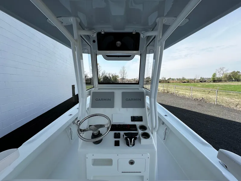 Slide: The Image of 2025 Pair Customs 27 boat cockpit with Garmin navigation, steering wheel, and controls. - 8