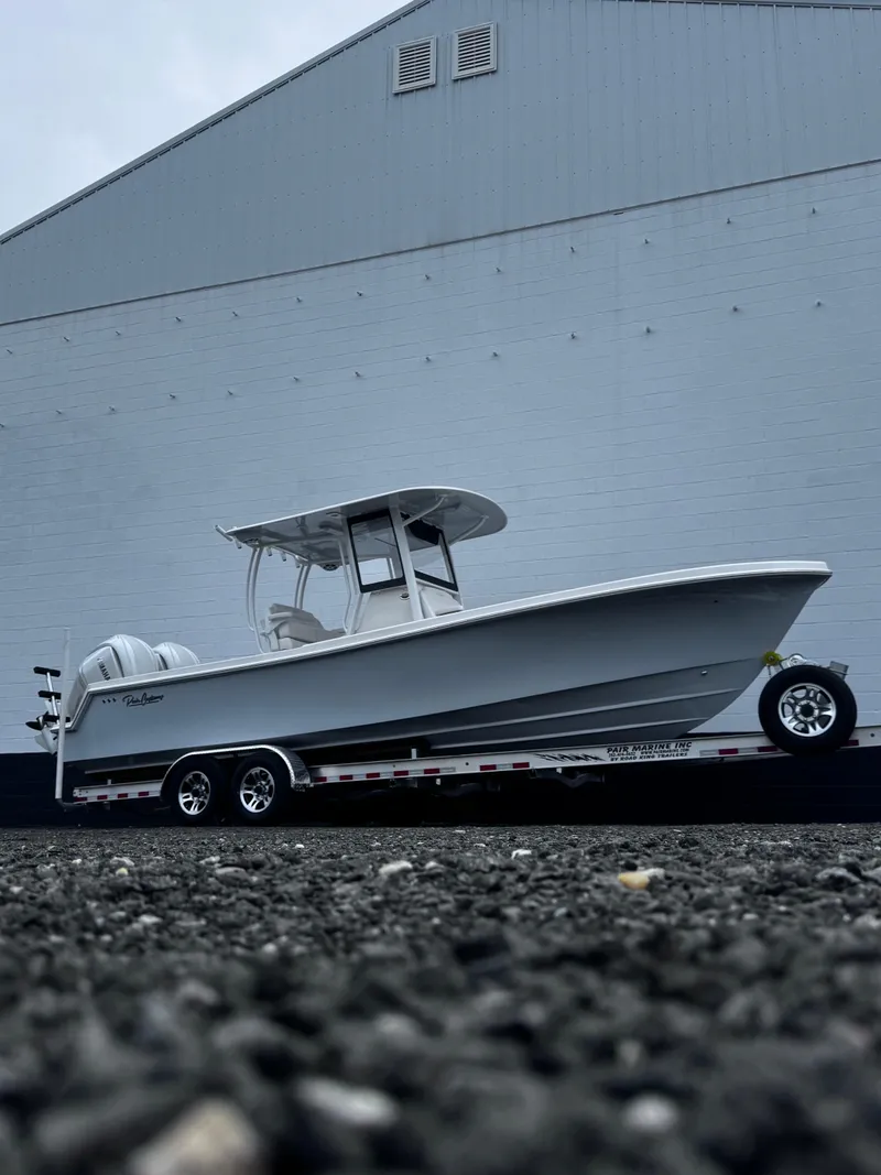 The Image of 2025 Pair Customs 27 boat on trailer, parked outside large building. - 1