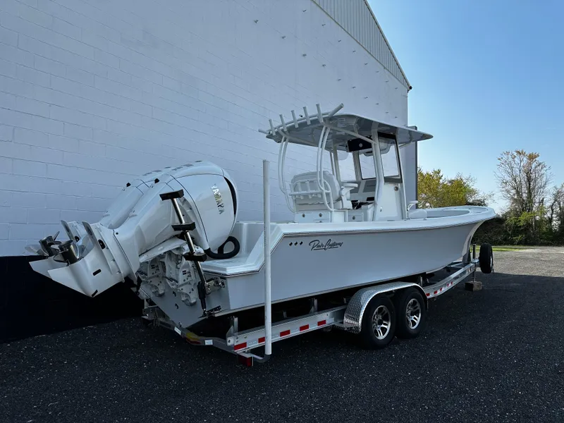Slide: The Image of 2025 Pair Customs 27 boat on trailer, white exterior, parked outdoors. - 5
