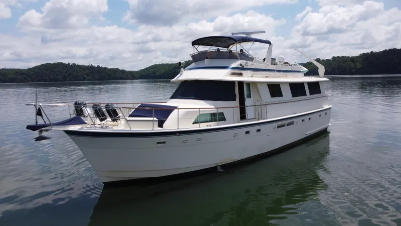 Slide: The Image of 1987 Hatteras 63 Motor Yacht on calm water under a partly cloudy sky. - 14