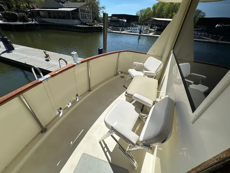 Slide: The Image of 1987 Hatteras 63 Motor Yacht deck with chairs overlooking marina. - 20