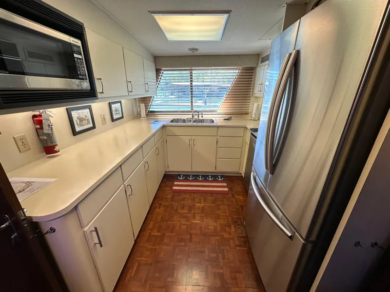 Slide: The Image of 1987 Hatteras 63 Motor Yacht kitchen with modern appliances and wood flooring. - 23