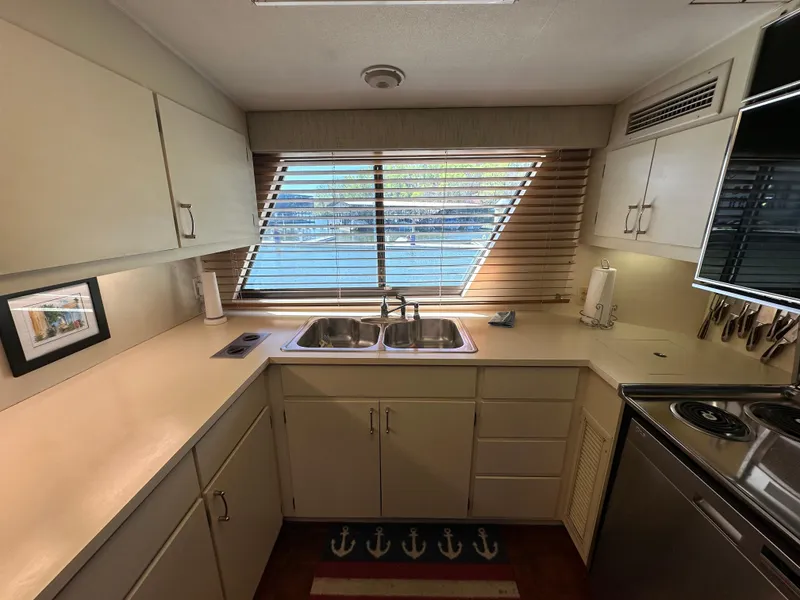 Slide: The Image of 1987 Hatteras 63 Motor Yacht kitchen with dual sinks, cabinets, and large window. - 27