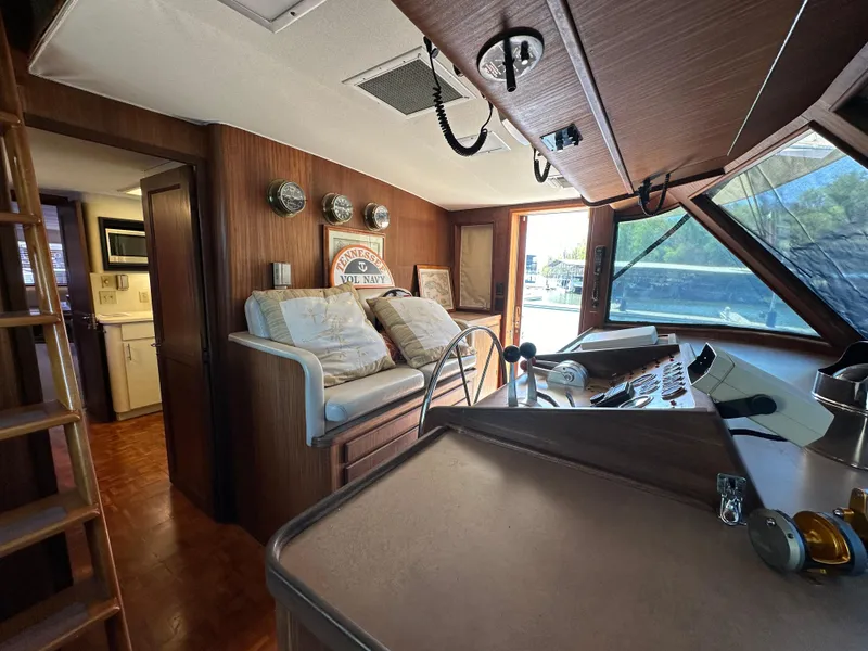 Slide: The Image of 1987 Hatteras 63 Motor Yacht interior with helm, seating, and wood paneling. - 32