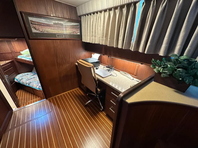 Slide: The Image of 1987 Hatteras 63 Motor Yacht interior with wood paneling, desk, chair, and bunk beds. - 34
