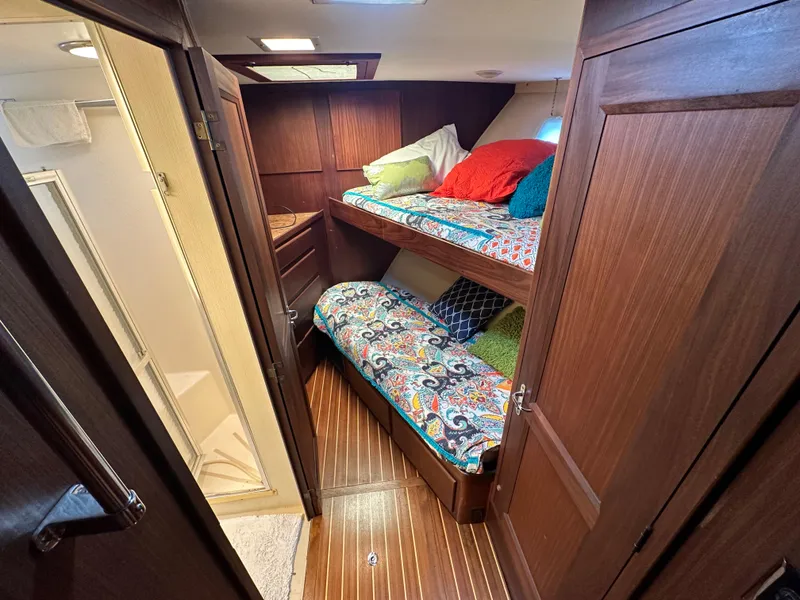 Slide: The Image of Cozy cabin with bunk beds in 1987 Hatteras 63 Motor Yacht, featuring colorful bedding. - 35