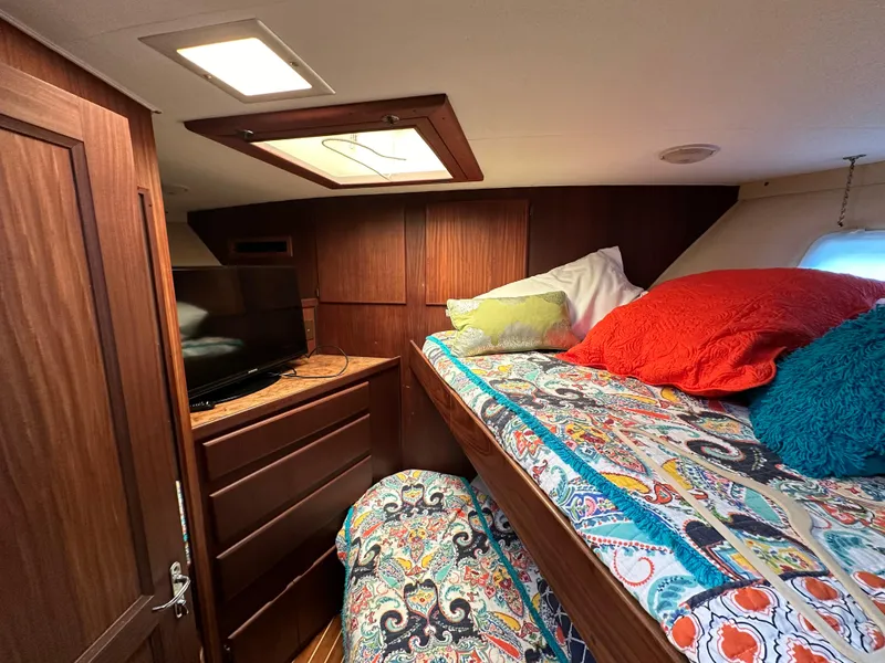 Slide: The Image of Cozy cabin interior of 1987 Hatteras 63 Motor Yacht with colorful bedding and wooden furnishings. - 36