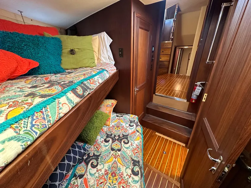 Slide: The Image of Interior of 1987 Hatteras 63 Motor Yacht with colorful bedding and wooden finishes. - 39