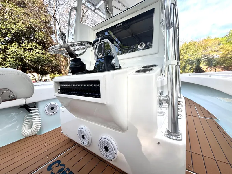 Slide: The Image of 2015 Contender 30 ST boat console with steering wheel and controls, featuring teak flooring. - 13