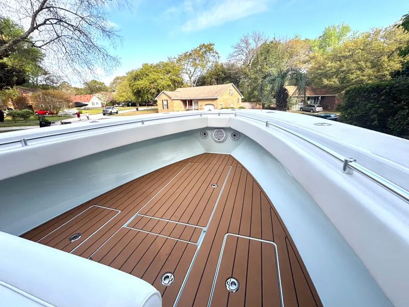 Slide: The Image of 2015 Contender 30 ST boat with sleek deck design in a residential area. - 15