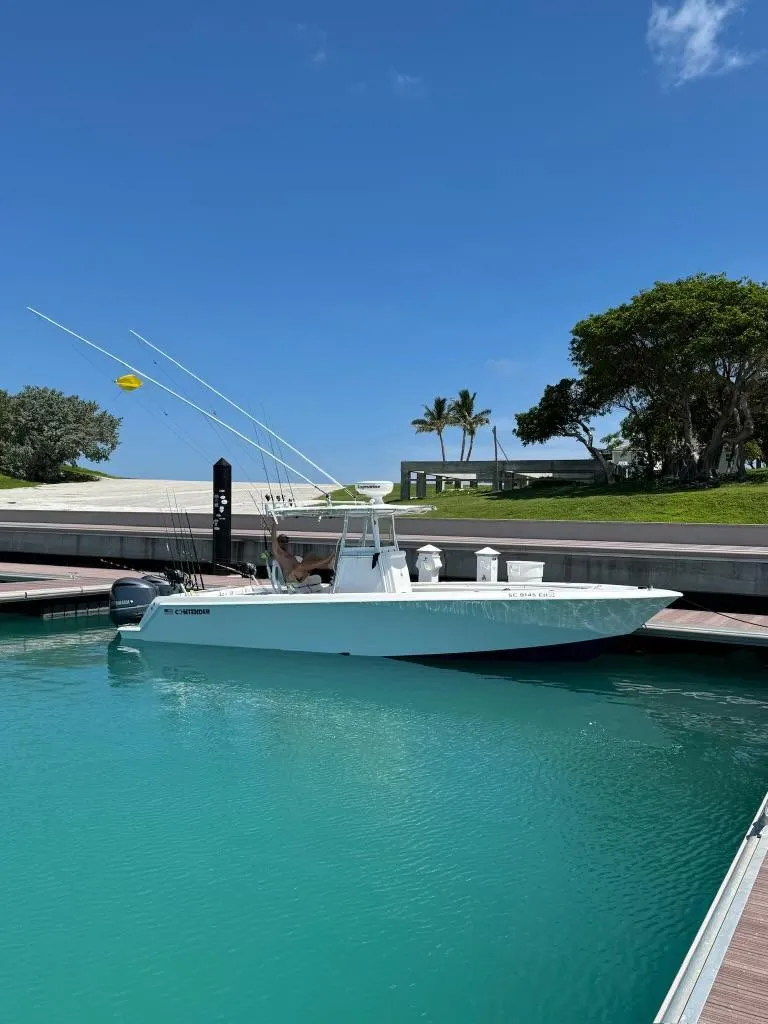 Slide: The Image of 2015 Contender 30 ST boat docked in clear turquoise water under a blue sky. - 18