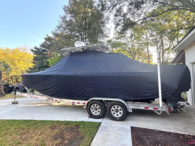 Slide: The Image of Covered 2015 Contender 30 ST boat on trailer in driveway, surrounded by trees. - 19