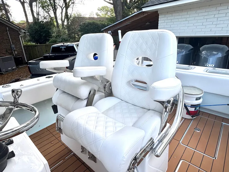 Slide: The Image of 2015 Contender 30 ST boat with white cushioned seats and dual outboard motors. - 2