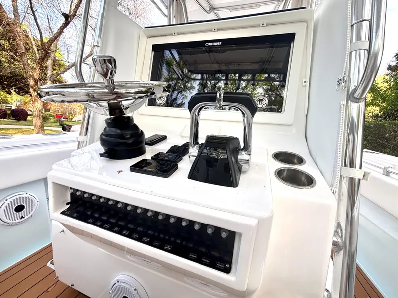 Slide: The Image of Control panel of a 2015 Contender 30 ST boat with steering wheel and electronics. - 24