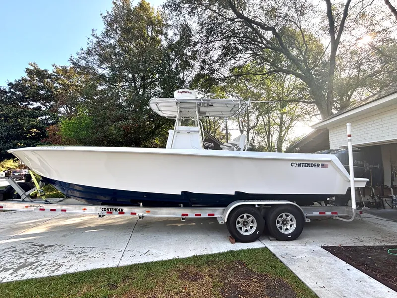 Slide: The Image of 2015 Contender 30 ST boat on trailer, parked in driveway, surrounded by trees. - 4