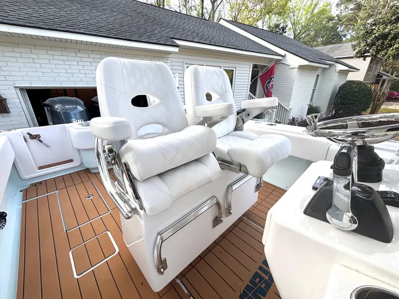 Slide: The Image of 2015 Contender 30 ST boat with white cushioned seats and wooden deck. - 6