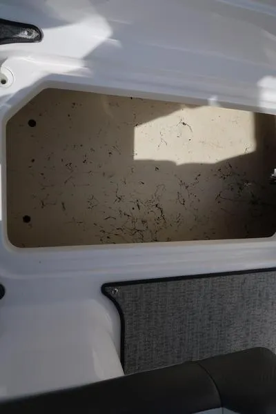 Slide: The Image of 2023 Hurricane SunDeck Sport 205 IO storage compartment, open and empty, with light shadows. - 23