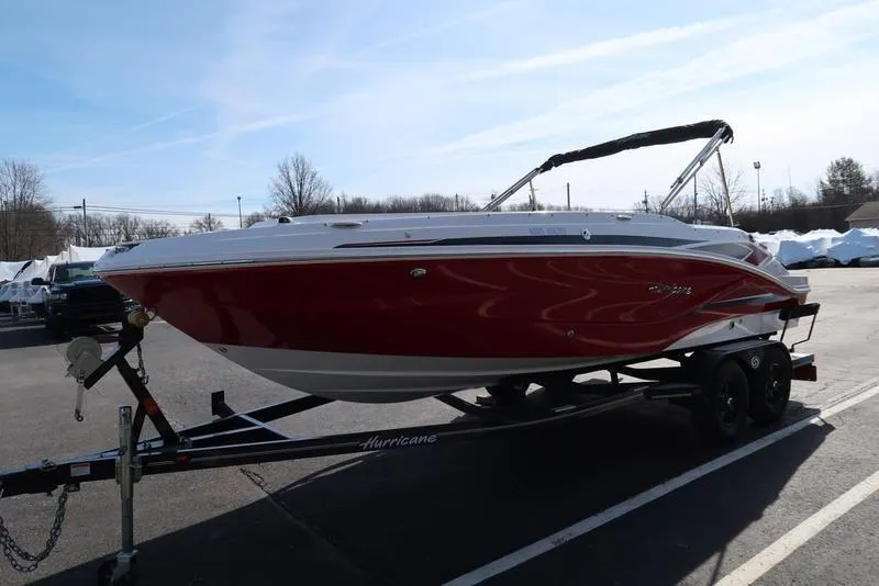 Slide: The Image of 2023 Hurricane SunDeck Sport 205 IO boat on trailer, red and white design, parked outdoors. - 5