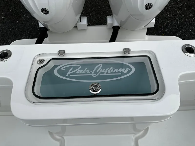 Slide: The Image of Pair Customs 24OS 2025 boat livewell with logo, featuring dual outboard motors. - 10