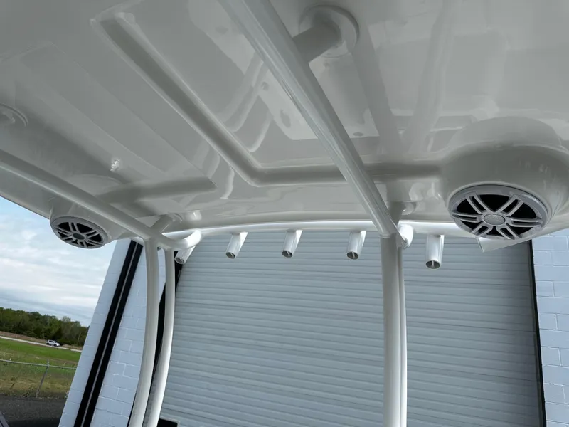 Slide: The Image of Rooftop view of 2025 Pair Customs 24OS boat with integrated speakers and rod holders. - 11