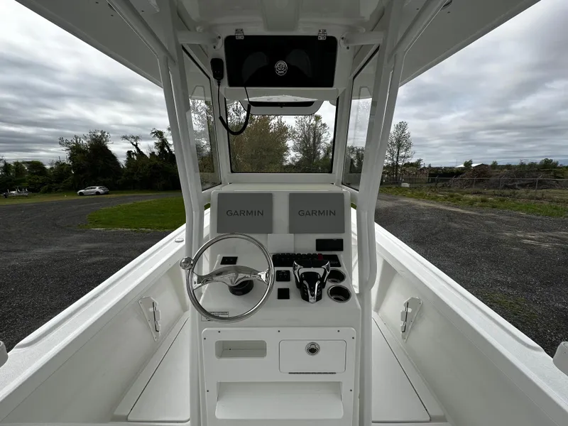 Slide: The Image of 2025 Pair Customs 24OS boat cockpit with Garmin navigation, steering wheel, and controls. - 15