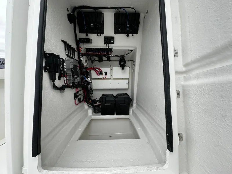 Slide: The Image of Interior view of 2025 Pair Customs 24OS boat compartment with electrical components. - 17