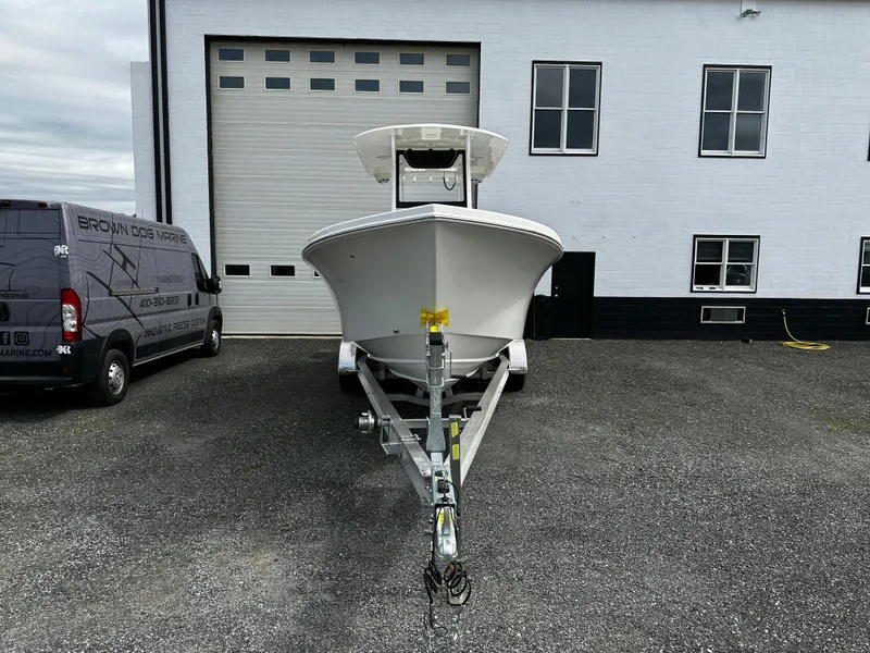 Slide: The Image of 2025 Pair Customs 24OS boat on trailer in front of a garage. - 3