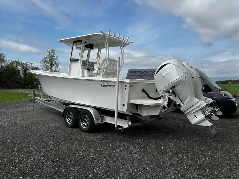Slide: The Image of 2025 Pair Customs 24OS boat on trailer, featuring a sleek design and powerful outboard motor. - 4