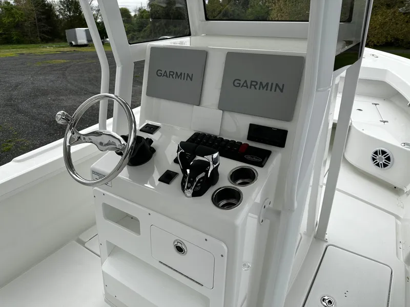Slide: The Image of 2025 Pair Customs 24OS boat dashboard with dual Garmin displays and steering wheel. - 6