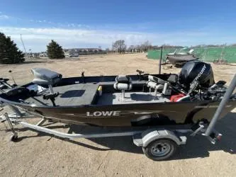 Slide: The Image of 2014 Lowe FM 160 T fishing boat on trailer, parked outdoors. - 1