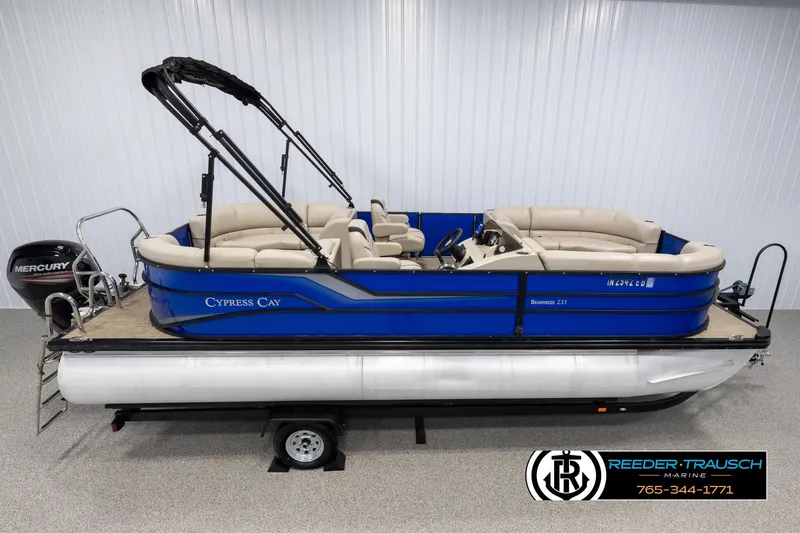 Slide: The Image of 2018 Cypress Cay 233 Seabreeze pontoon boat with blue exterior on trailer. - 0